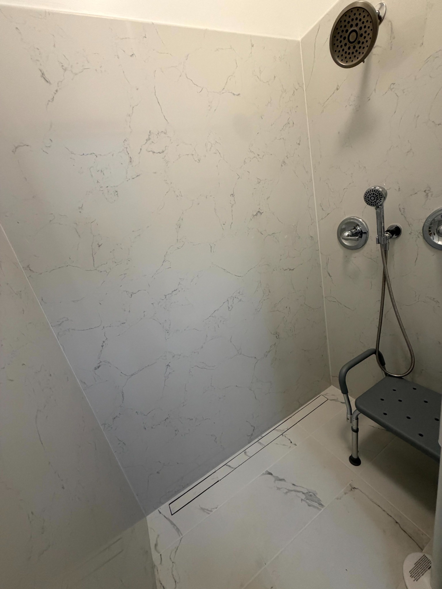 Curbless shower with linear drain and shower seat in West Sacramento
